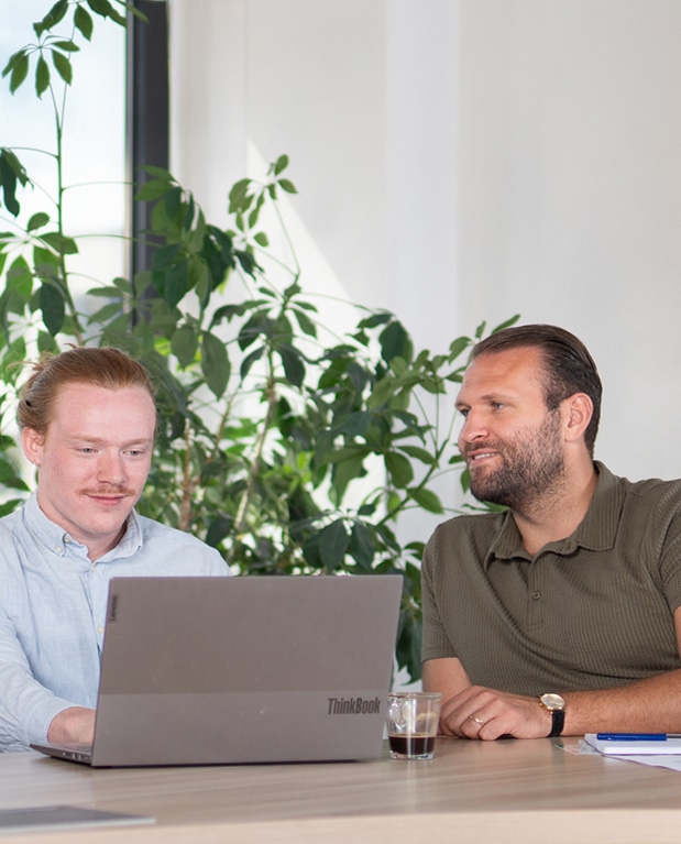 twee mannen die samen naar een laptop kijken