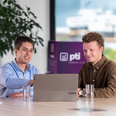 twee mannen die naar een laptop scherm kijken