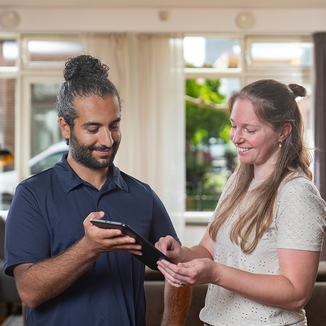 monteur met een ipad met een vrouw die een handtekening zet