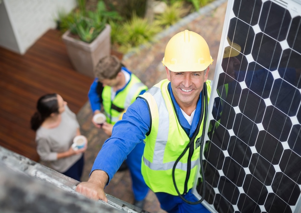 monteur op het dak aan het werk met zonnepanelen