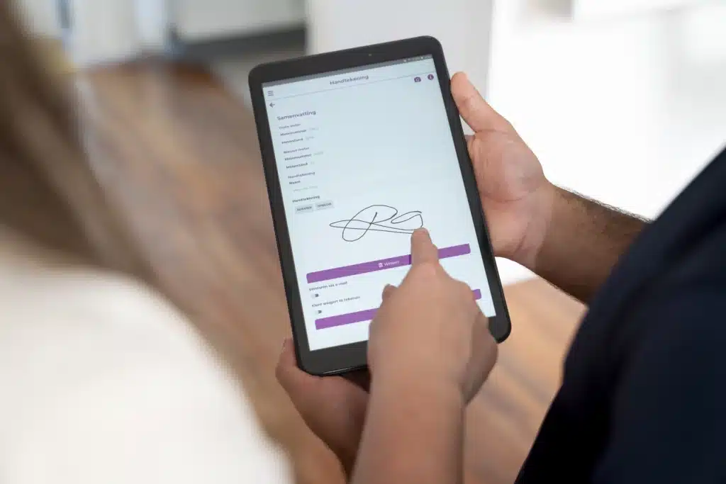 iemand zet zijn handtekening op een tablet