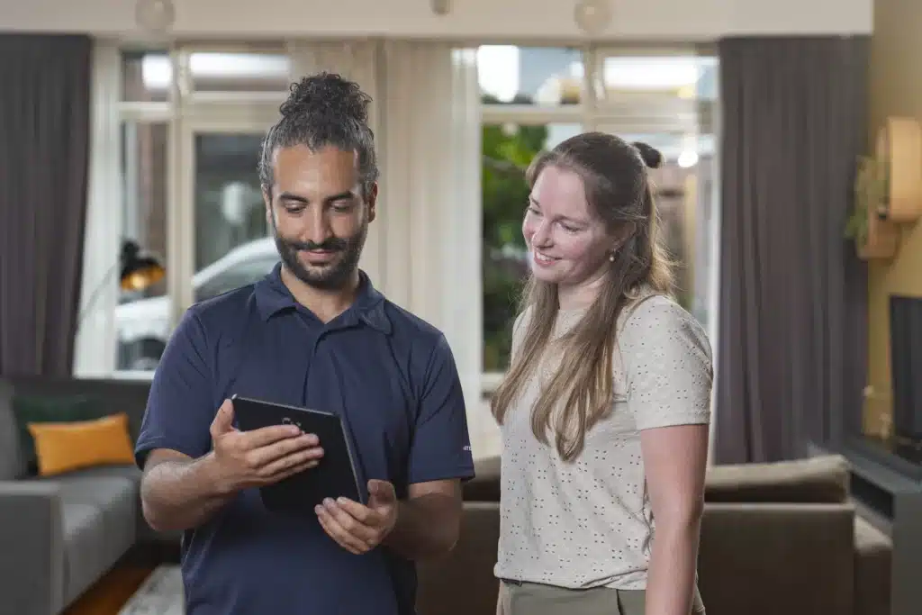 monteur en vrouw die samen naar een tablet kijken