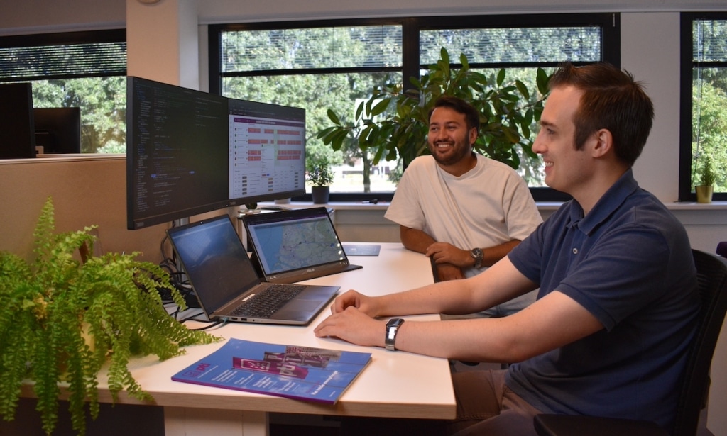 twee mannen aan het werk achter een computer