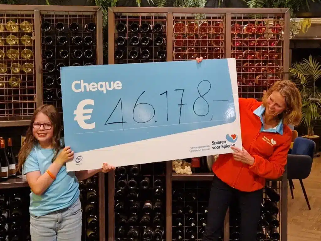 Spieren voor Spieren golfdag waarin de cheque omhoog gehouden wordt