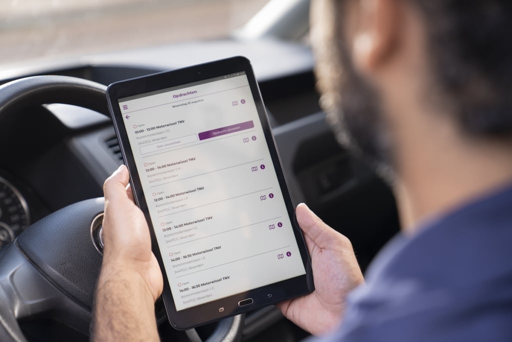 monteur die naar zijn planning op een tablet kijkt